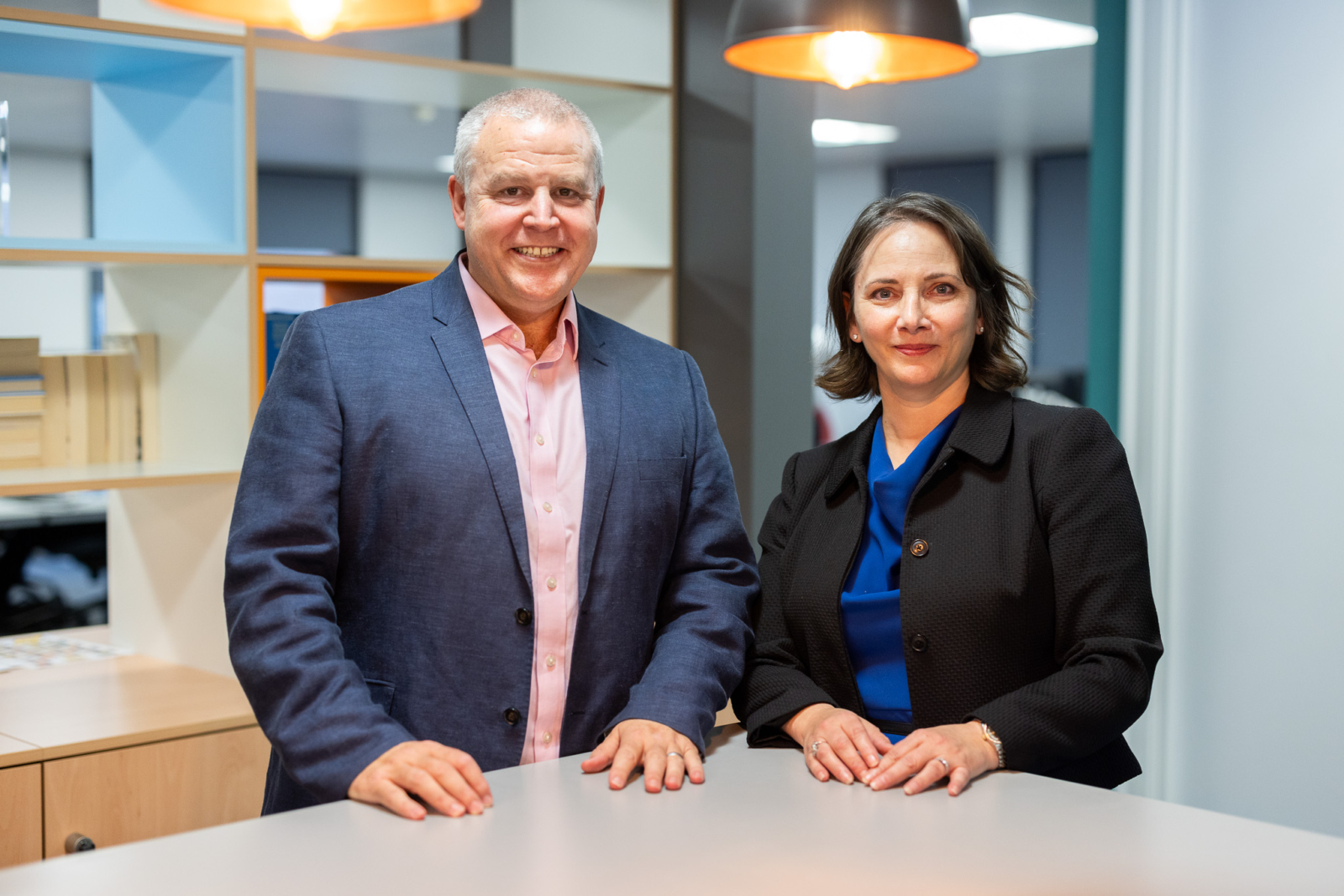 Two members of the HCR team in an office smiling