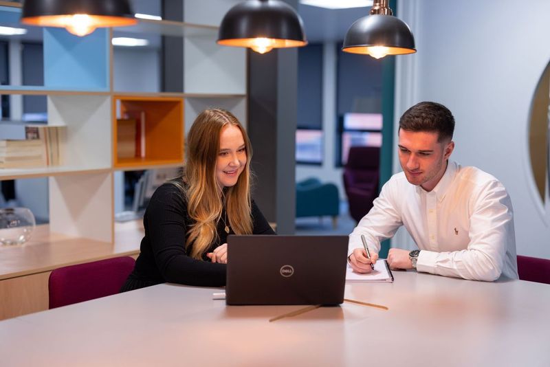 Two people viewing something on a laptop