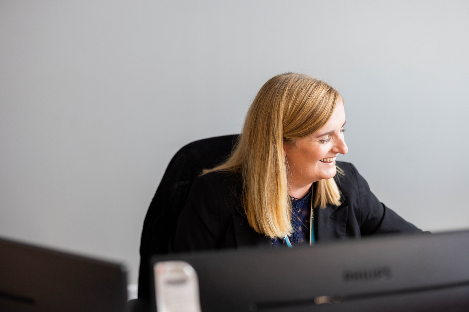 A woman working on a computer smiling