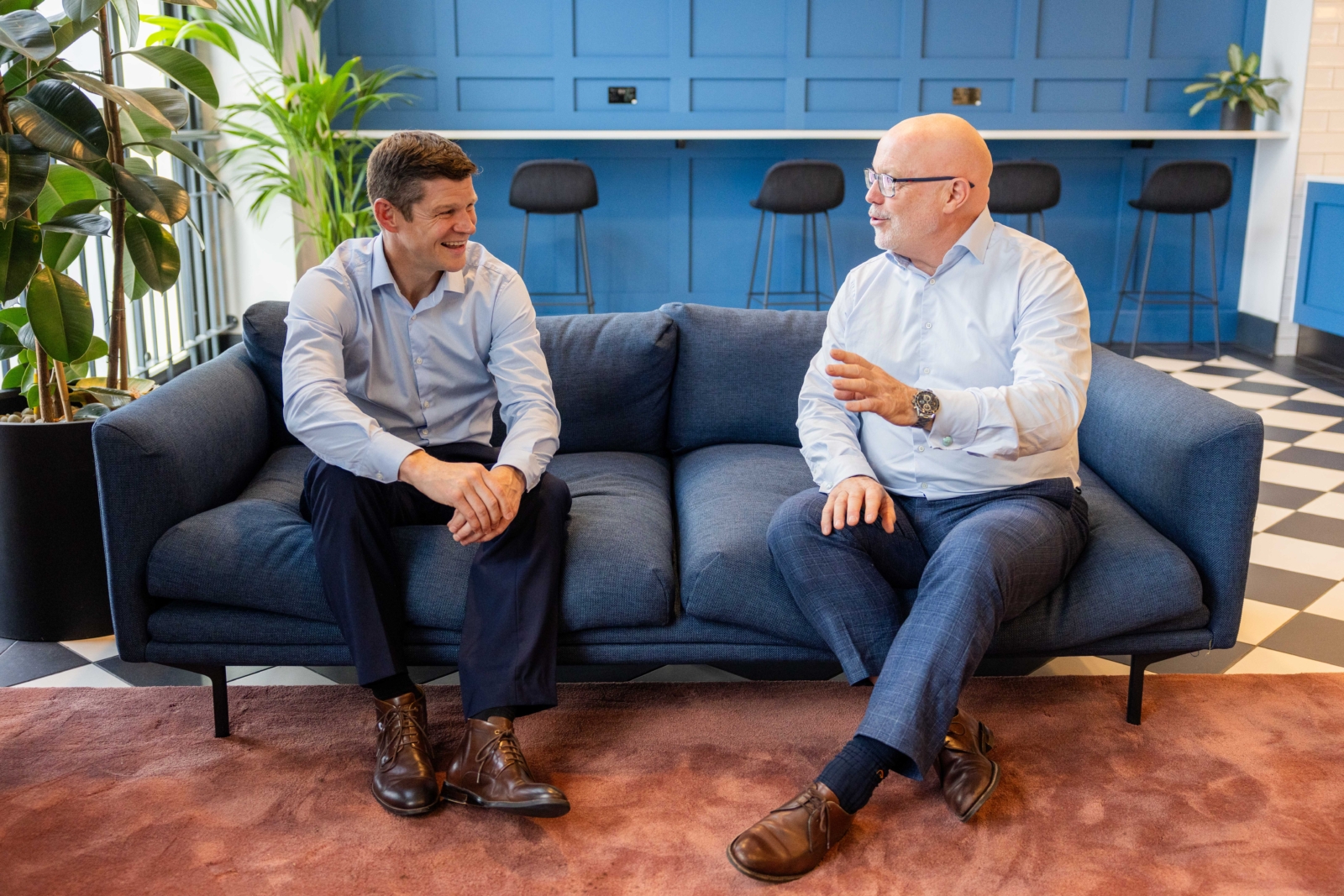 Two members of our team mid conversation on a sofa in our Cardiff office