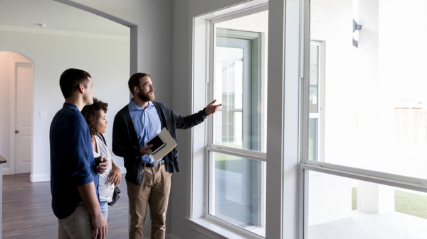 three people looking out of a window in a new house