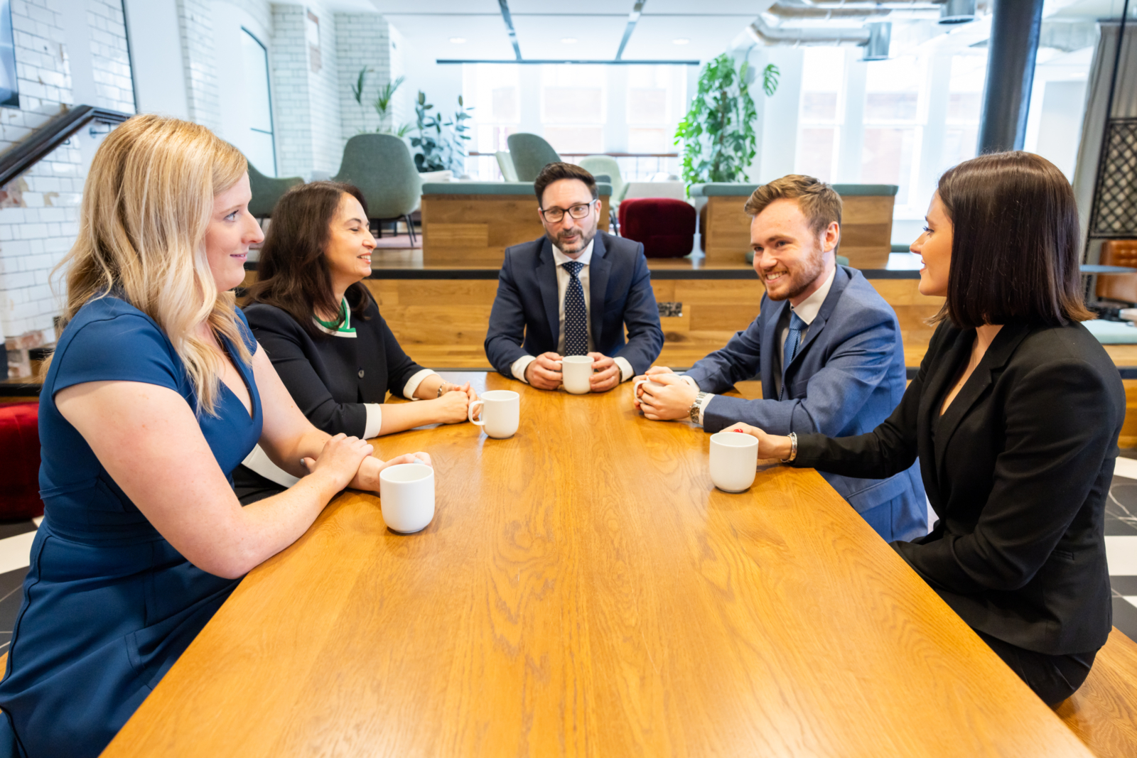 A group of solicitors sitting around a wooden table