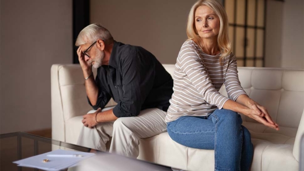 Woman and man not facing each other and man has his head in his hands