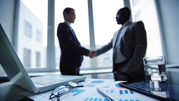 Two men shaking hands infront of the window