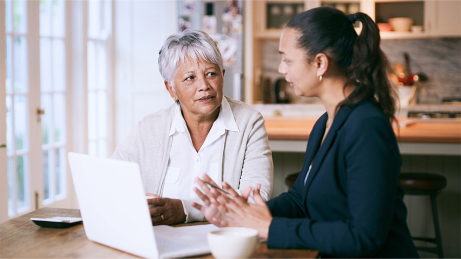 Two women talking infront of a laptop