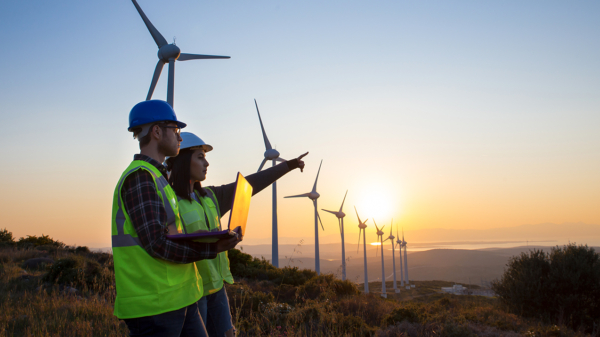 Two people by a wind farm