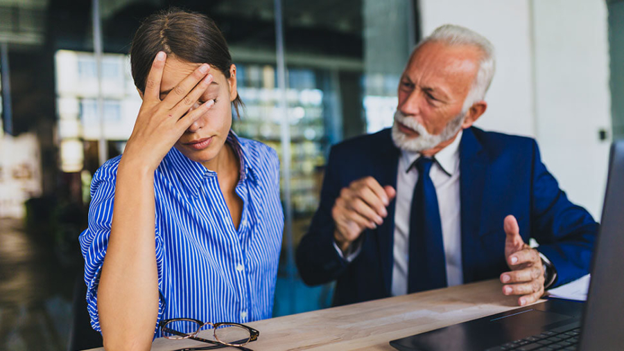 Man talking to woman who has her head in her hands