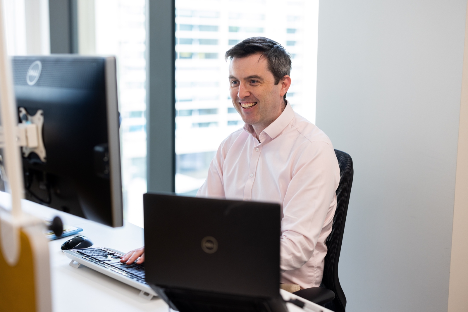 A man looking at a computer smiling