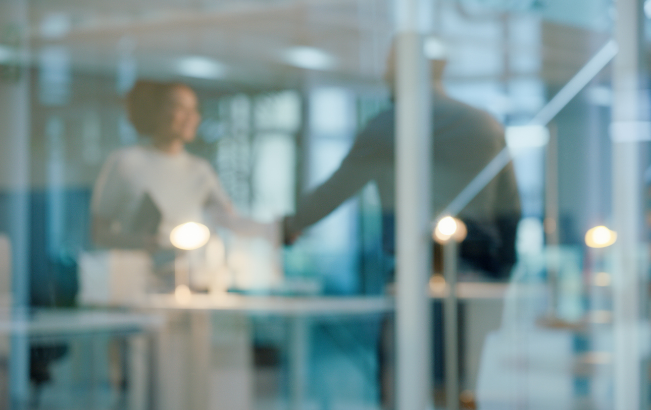 Glass, modern office and business people with handshake,