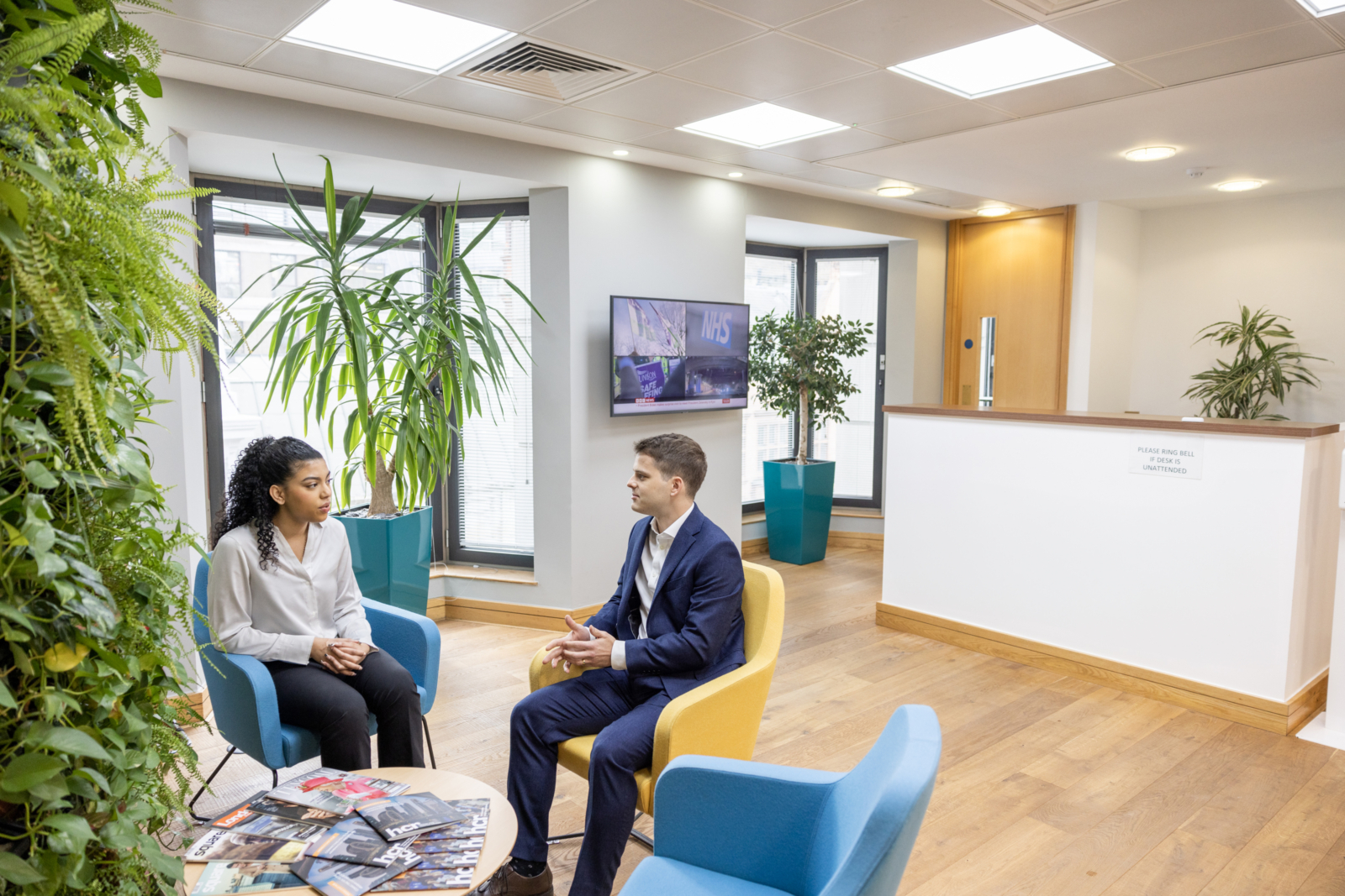 2 people sat in office reception having chat, Harrison Clark Rickerbys