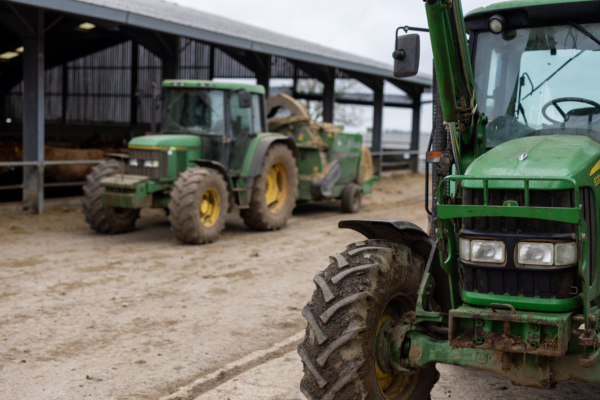 Two green tractors, one close to camera, one in background