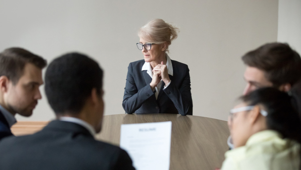 A woman in a business suit sitting at a table with colleagues during a employment appeal tribunal.