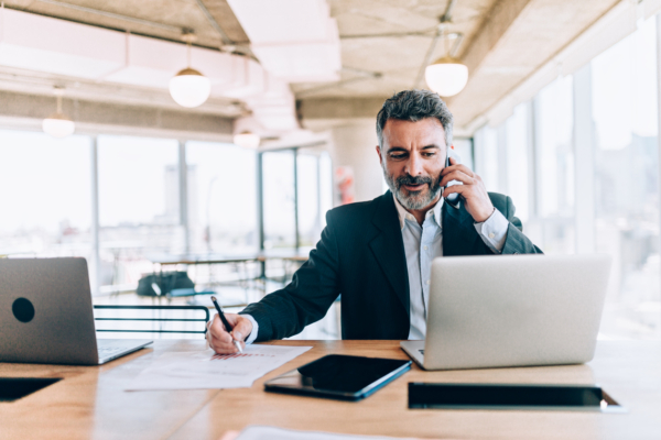 A male solicitor on the phone and working on a laptop