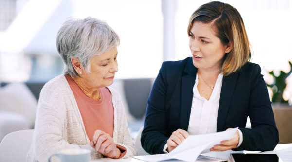 A senior lady and a business woman discussing documents