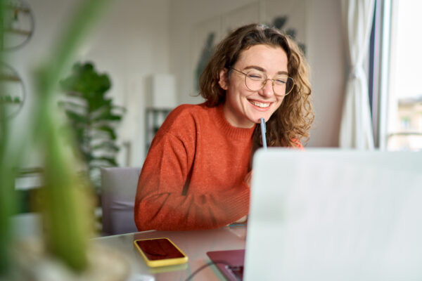 Smiling young woman on laptop