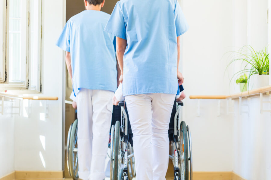 Two carers pushing wheelchairs