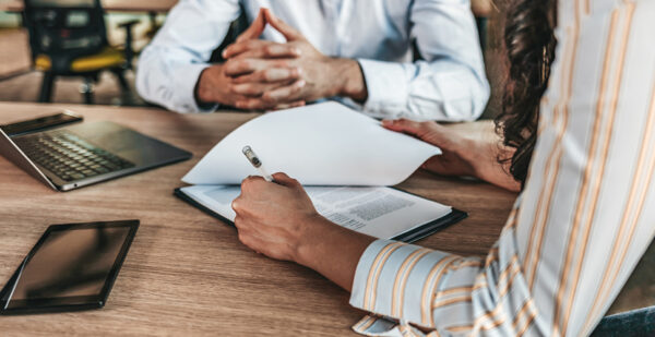 Two people reading a ledger