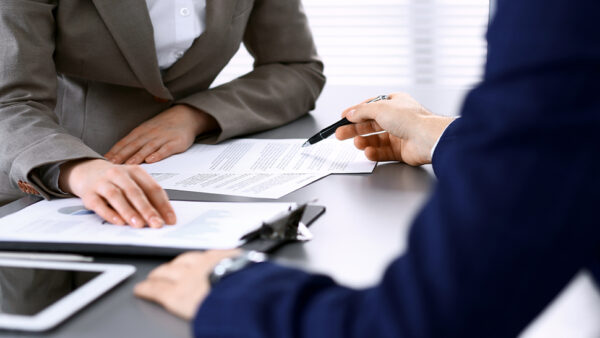 Image of two people signing an agreement