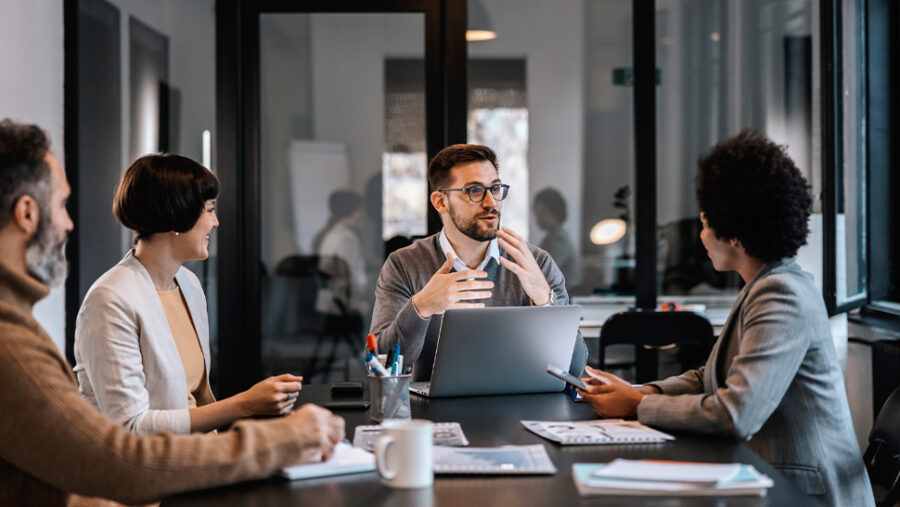 Group of people sitting around the desk, working and sharing ideas