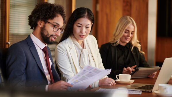 Team of people, in an office, looking over documents