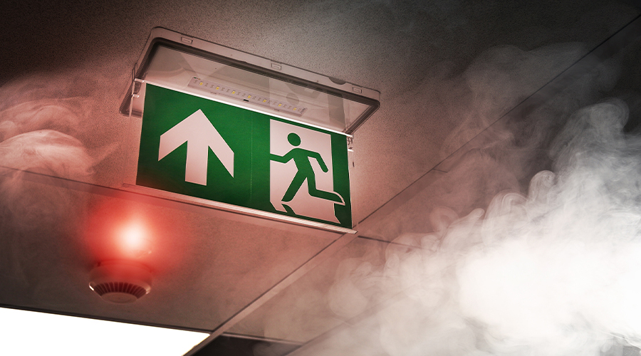 A picture of a fire escape sign covered with smoke from a fire