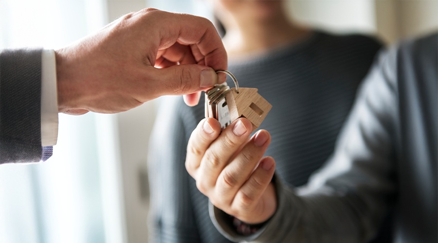 A person passing the keys to a house over