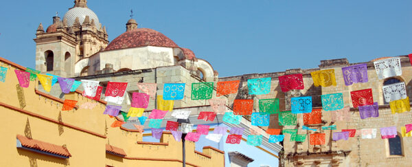 Image of Mexican town, with colourful flags and white buildings