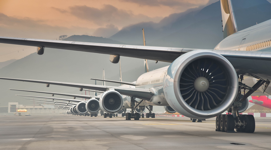 A picture of a row of planes on a taxiway