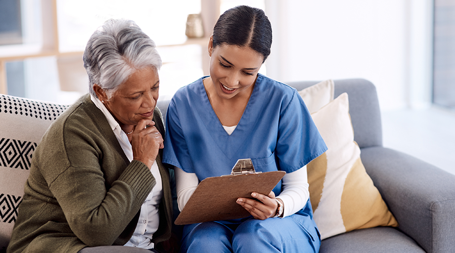 A young nurse going through paperwork with a senior woman
