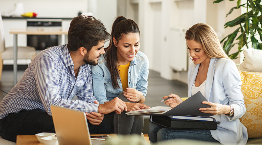 Three people discussing their real estate portfolio