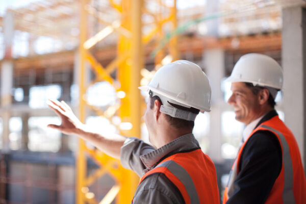 Two investigators overseeing the construction of a building