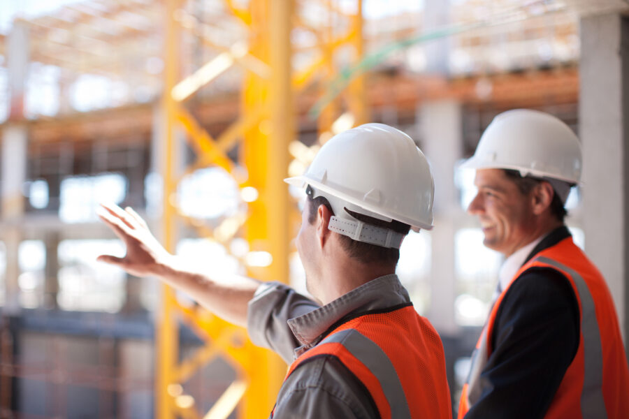 Two investigators overseeing the construction of a building