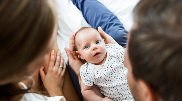 New parents holding a baby