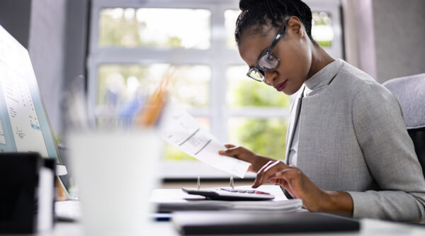 Female looking over papers and calculator