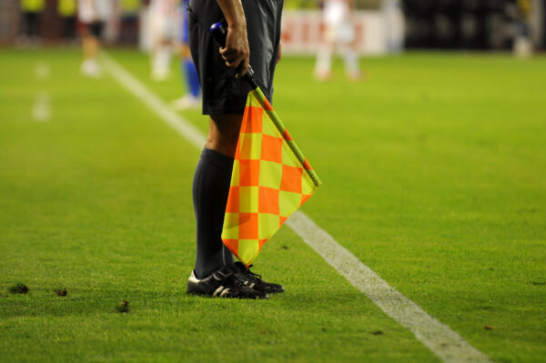 A linesman with a flag at a football match