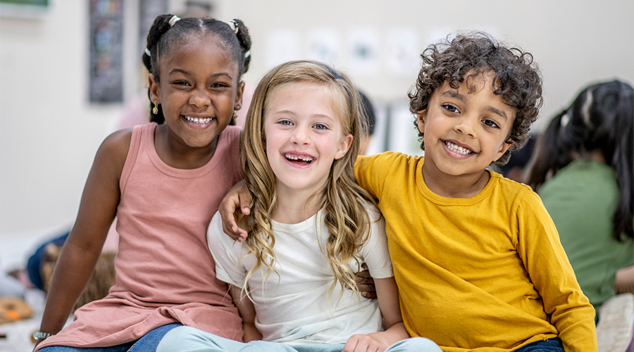 three children smiling at school