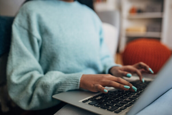 A lady tapping on the laptop
