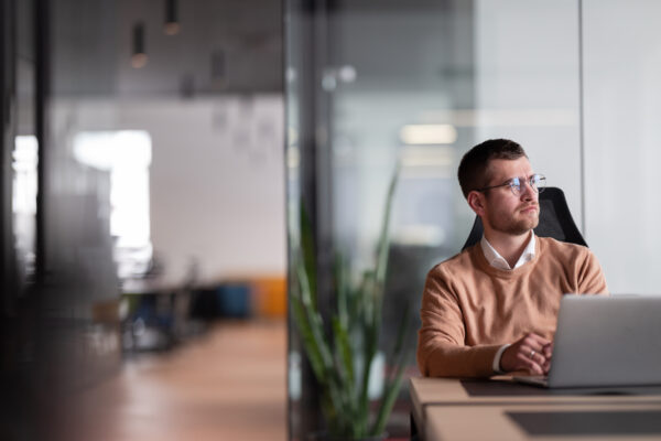 Businessman in glasses distracted from computer work