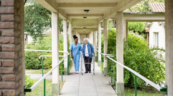 A carer with their patient at a care home