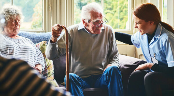 Carer with elderly couple sitting on the sofa
