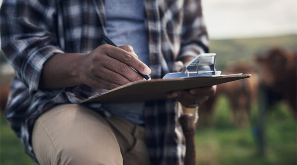 A farmer checking a clipboard