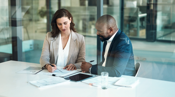 People in a glass office looking over documents