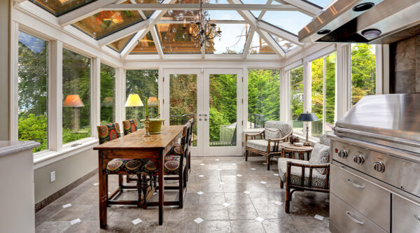 Conservatory-style sunroom extension with full glazing, dining and seating space, representing home improvement and planning considerations for homeowners