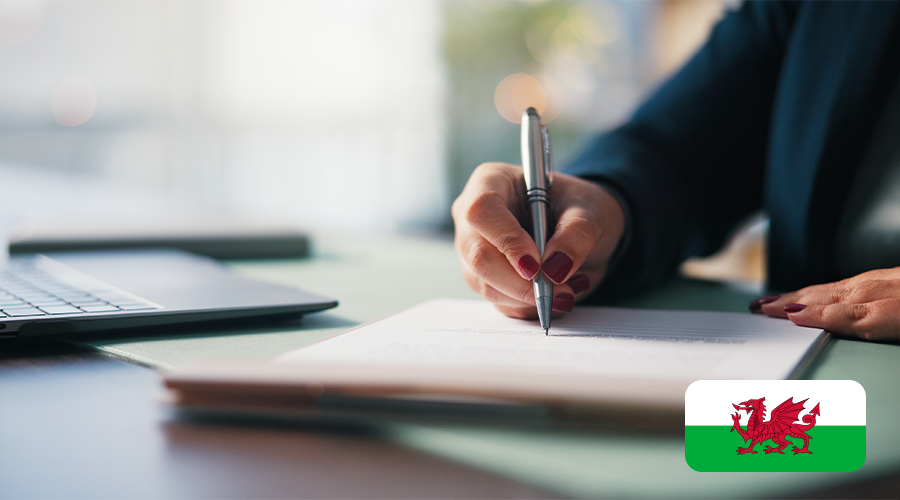 A hand signing a document