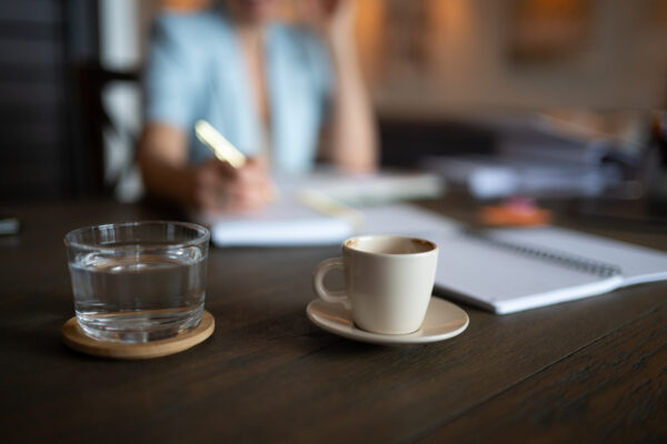 Professional is working at desk with coffee and water.
