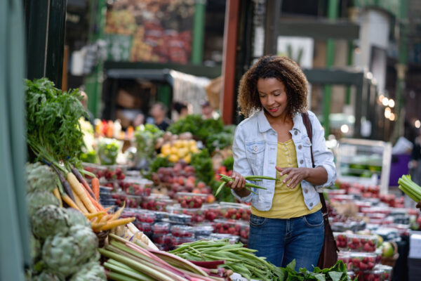 African American woman buying food at an organic market - lifestyle concepts
