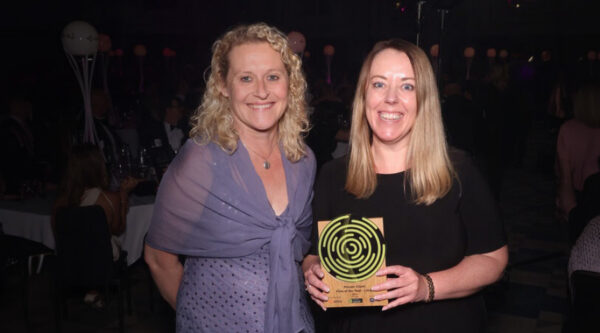 Two Partners standing holding an award