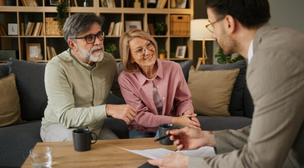 Couple discussing pension and benefit planning with a professional adviser.