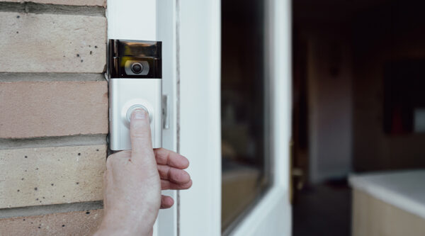 Someone pressing a video doorbell