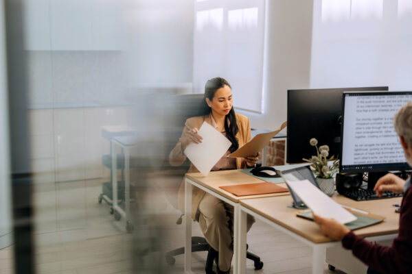 Professional reviewing recruitment documents with a colleague in a modern office.